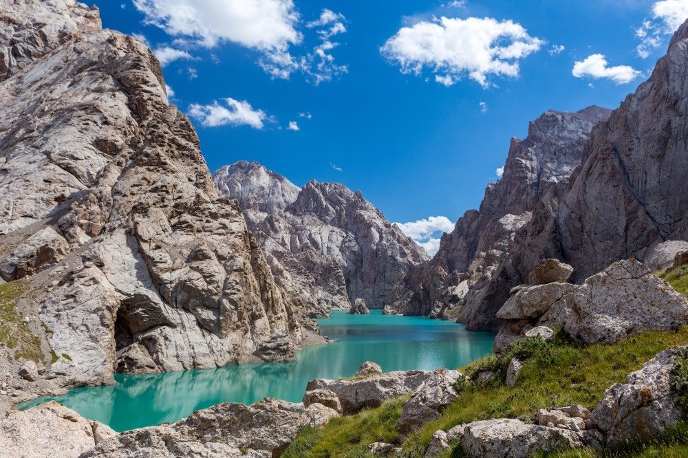 Turquoise Kel-Suu lake between steep rock walls