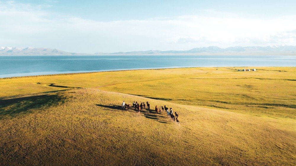 Riders crossing a high pasture above Song-Kul lake in Kyrgyzstan